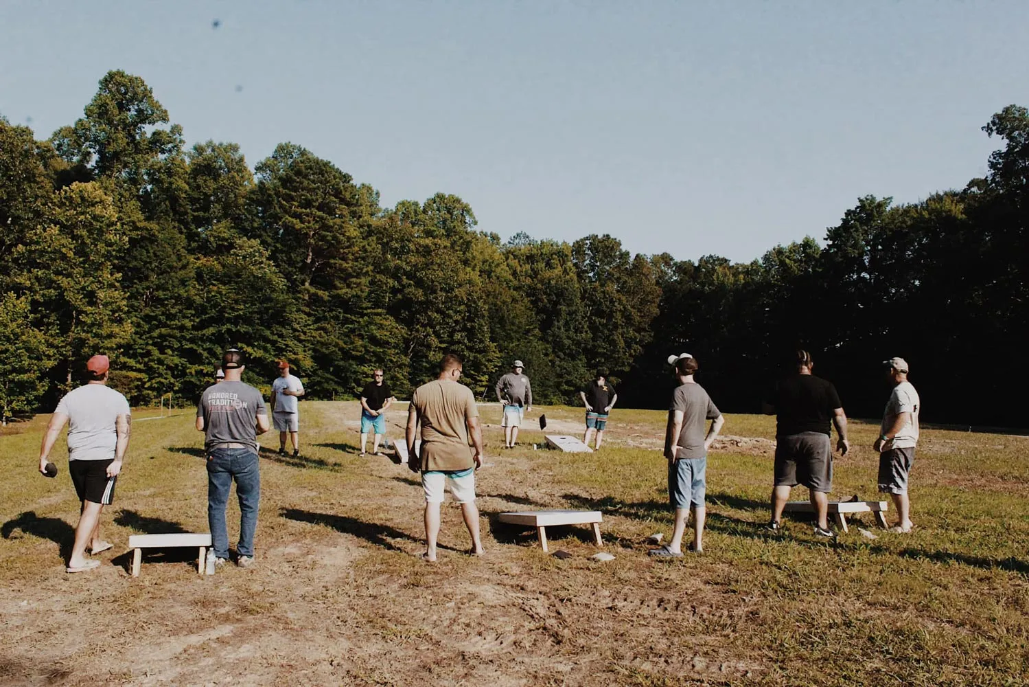 Veterans playing cornhole together in an open field at a Warrior Ridge reconnection retreat in Lewis County, Kentucky